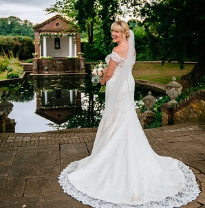 Micklefield Hall wedding, bride standing in front of temple and pond in wedding dress