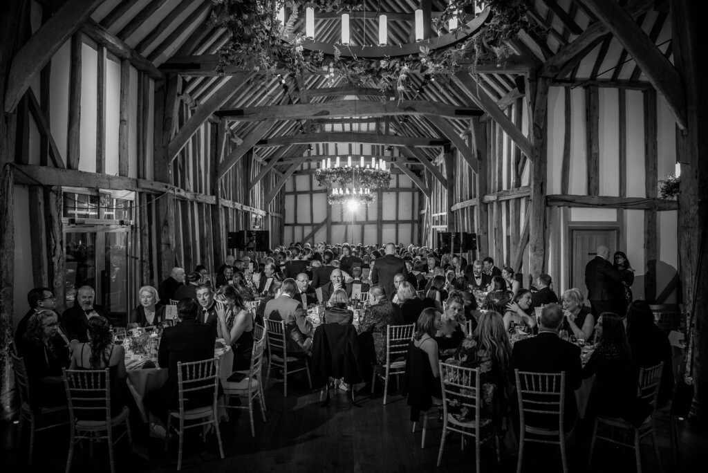 The Great Barn full of guests sitting around round tables