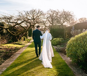 the newly married couple enjoying a walk through the gardens at micklefield hall during their february wedding