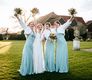 The bride and her bridesmaids waving their bright bouquets in the air