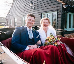 Bride and groom smile as they arrive to micklefield hall for their february wedding