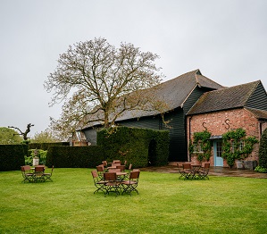 lawn area with garden tables and chairs on a rainy wedding day at micklefield hall 